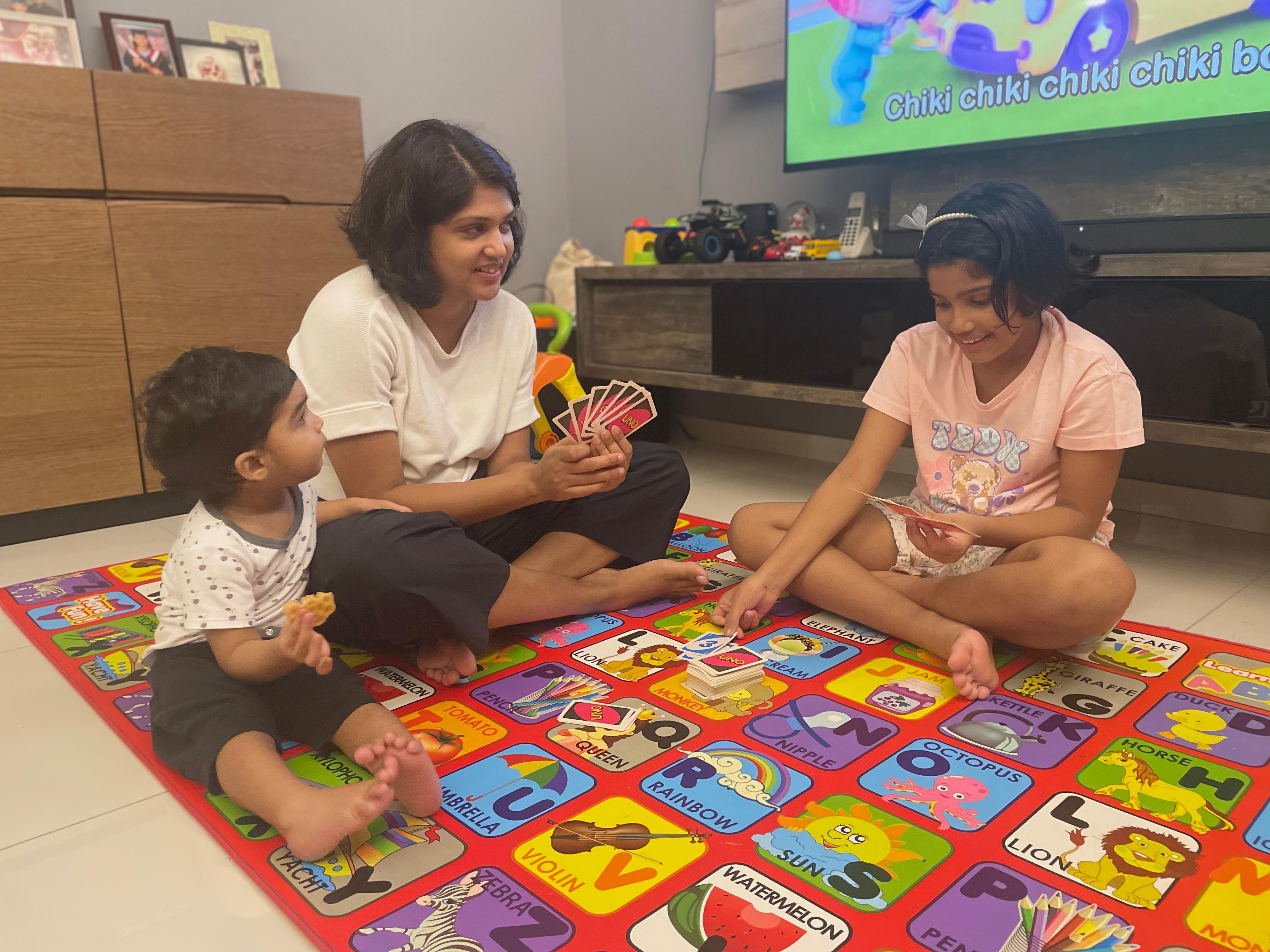 Nimmi spending quality time with her children, playing board games.